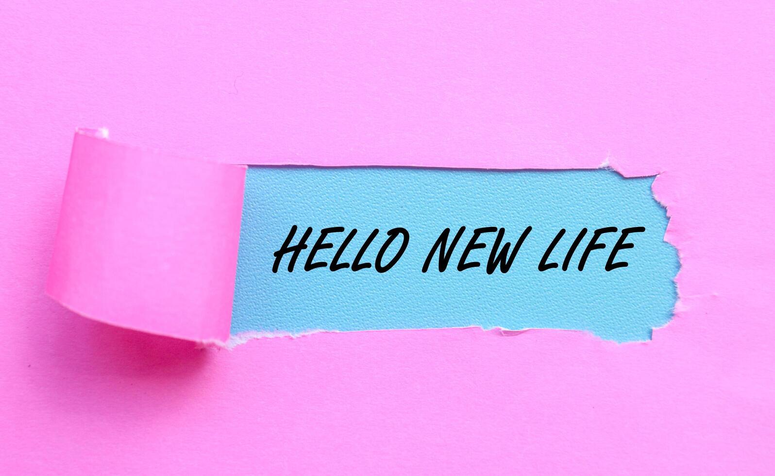 Words HELLO NEW LIFE on blue background and torn pink paper. Ripped paper with new life word, new life motivation concept photo