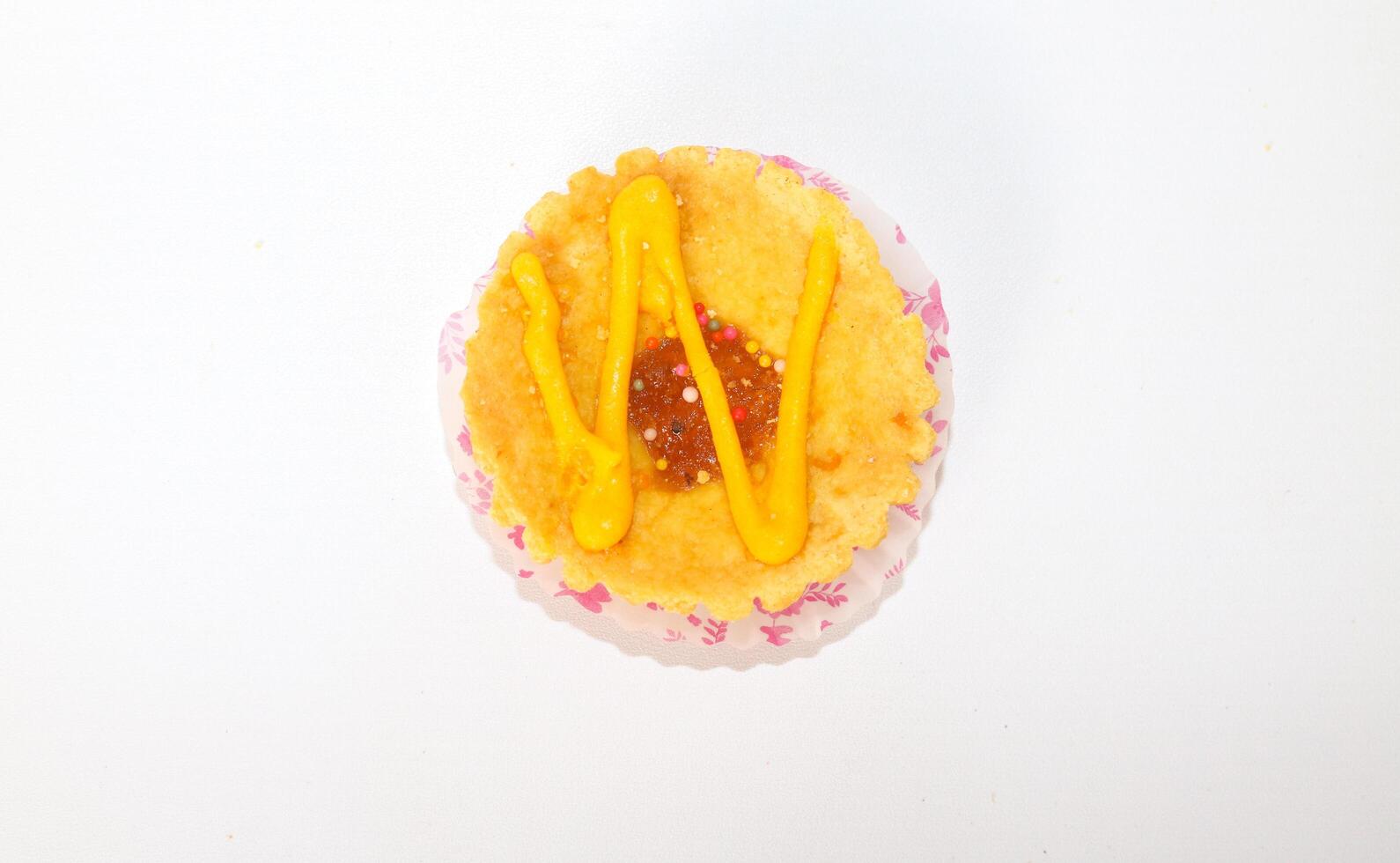 One mini pies with colorful topping decoration. small tart cakes and pies isolated on white background. Small cupcakes with colorful chocolate decoration photo