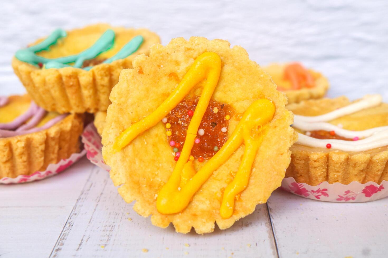 Close up mini pies with colorful toppings. small tart cakes and pies on white background. Chocolate flavored cake photo