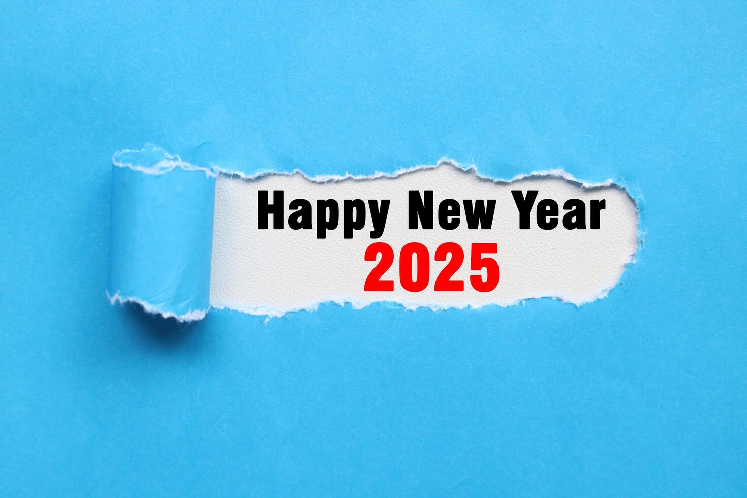 Happy new year 2025 on blue torn paper. Plans for the new year 2025. New year greetings photo