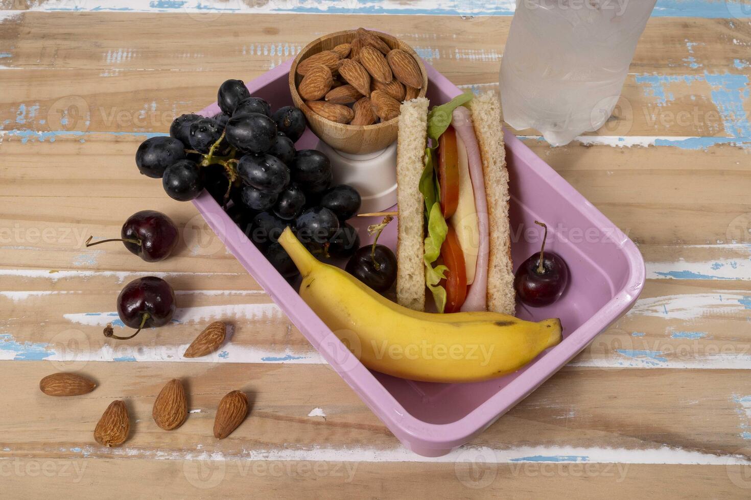 School lunch presentation. Top view showing lunch box filled with nutritious foods, protein, fruit and grains photo