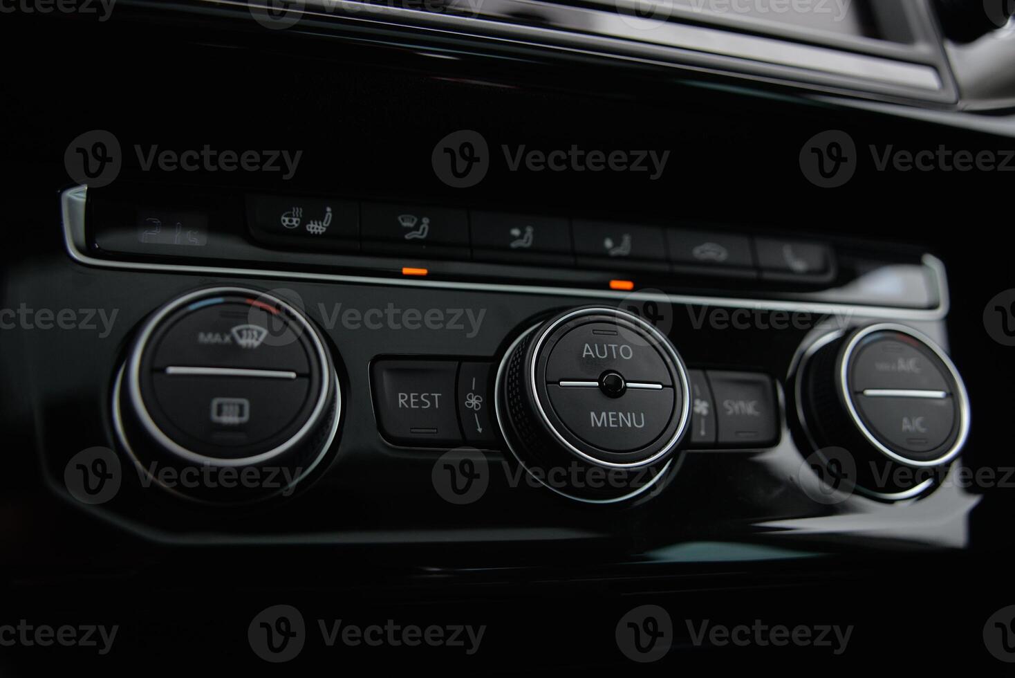 Modern car climate control panel with buttons and dials for temperature fan speed and AC photo
