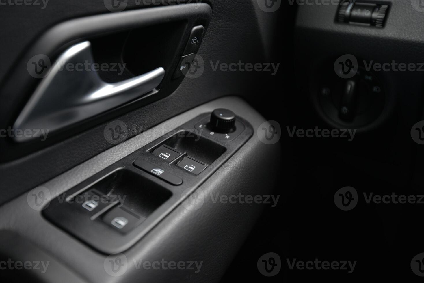 Close up of car door panel with window controls and door handle photo
