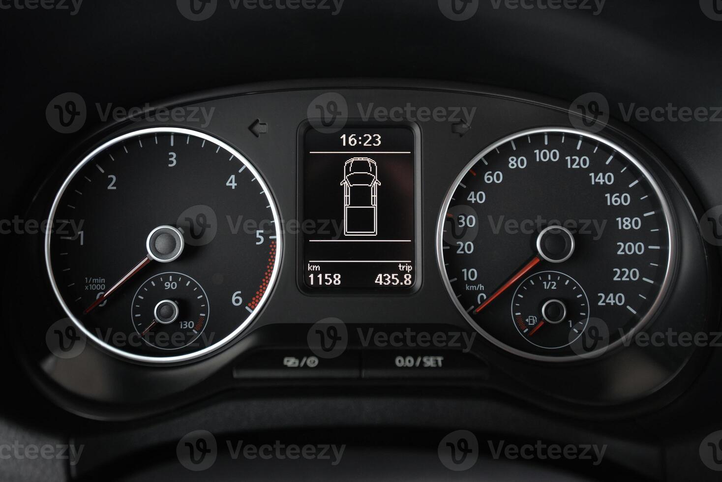 Close up of a car's instrument panel displaying speed RPM and trip information photo