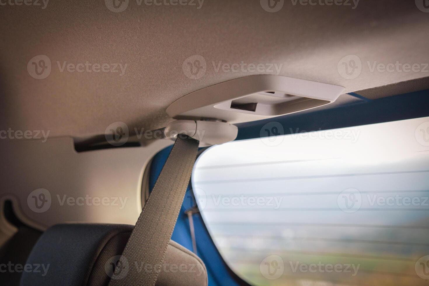 Close up of a car's rear seatbelt and overhead console photo