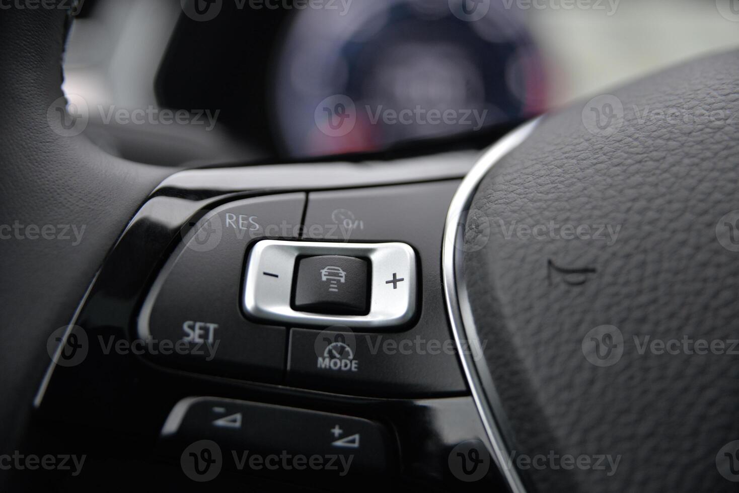 Close up of a car's steering wheel controls featuring buttons for cruise control mode selection and settings adjustments photo