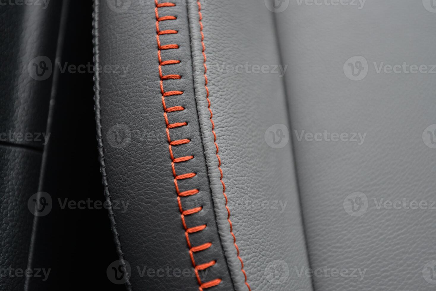 Close up of gray leather upholstery with orange stitching High quality texture and detail photo