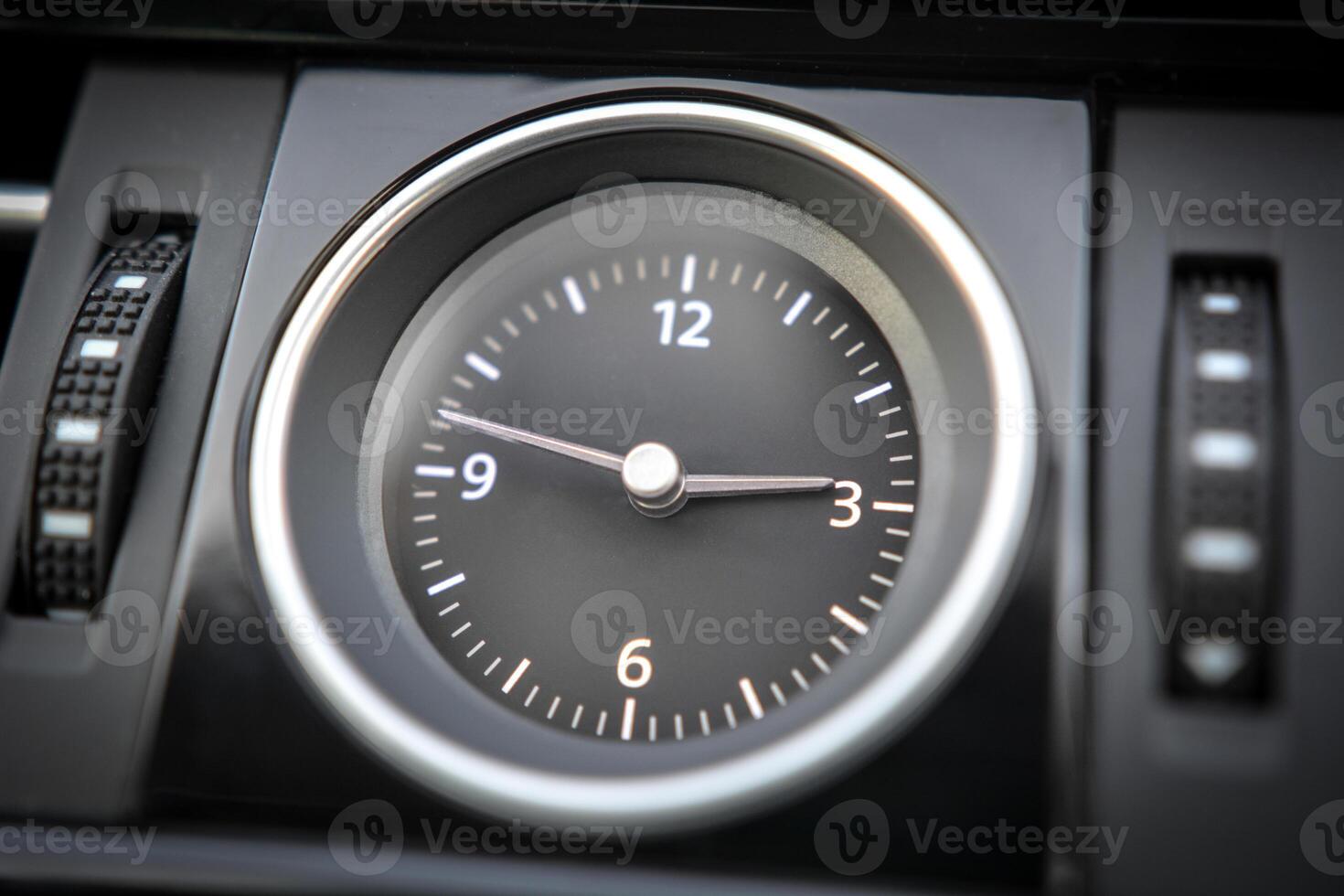 Close up of an analog clock in a vehicle's dashboard photo