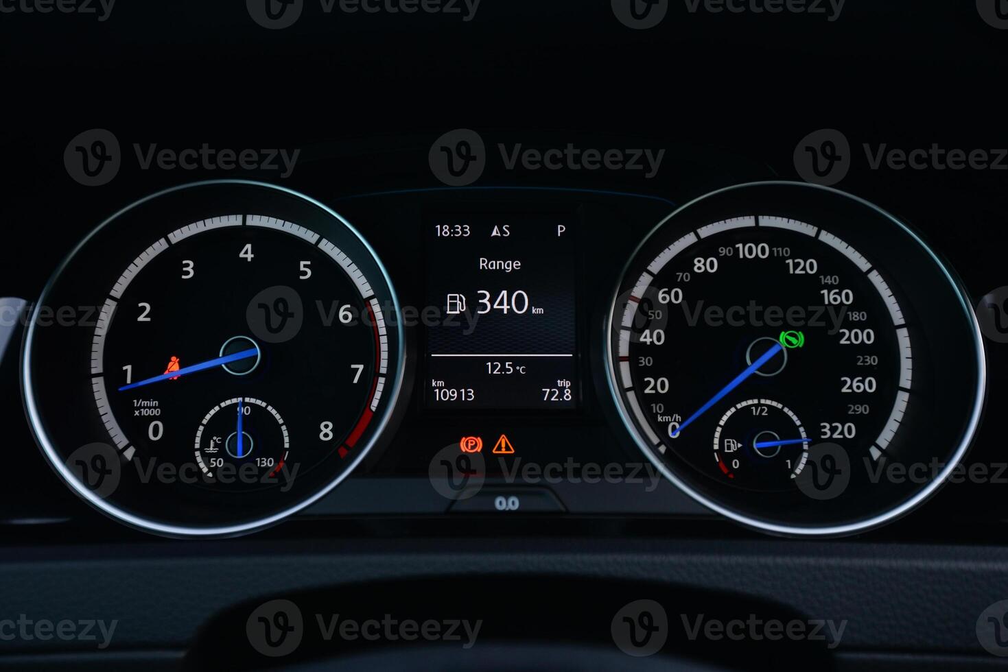 Close up view of a car's instrument panel showing the speedometer tachometer and fuel gauge photo