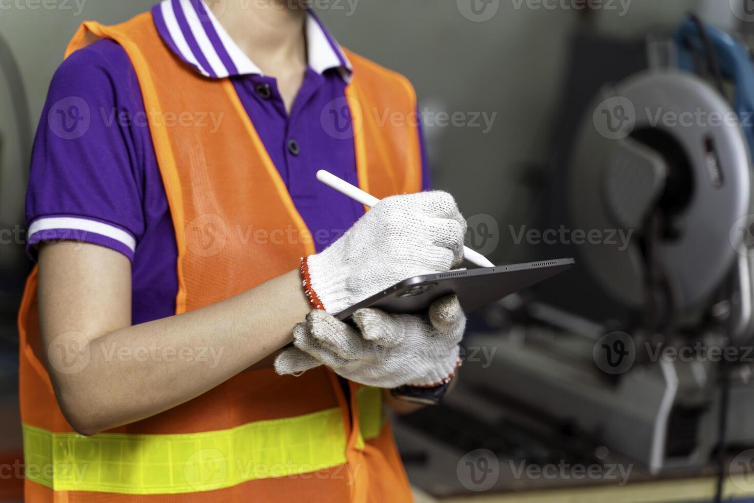 Closeup and crop hands of industrial engineer checking of work on tablet at industrial workshop. photo
