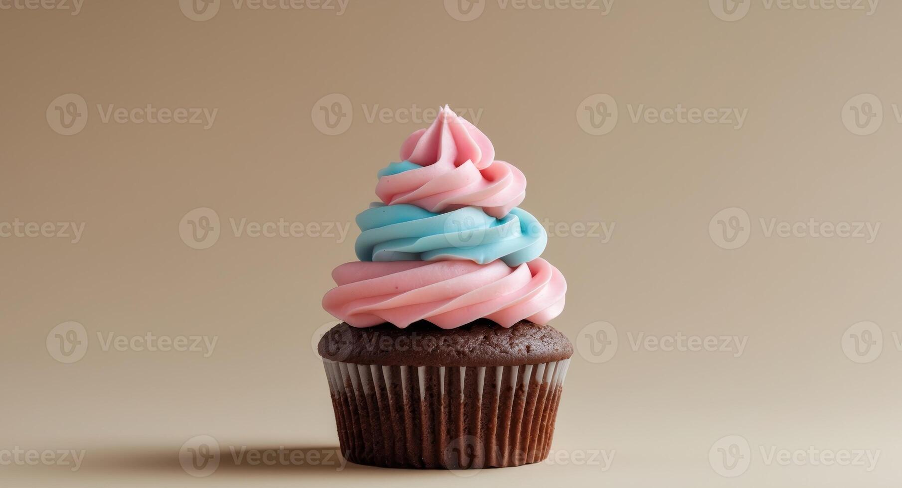 Chocolate cupcake with pink and blue swirled frosting on beige backgroundChocolate cupcake with pink and blue swirled frosting on beige background. photo