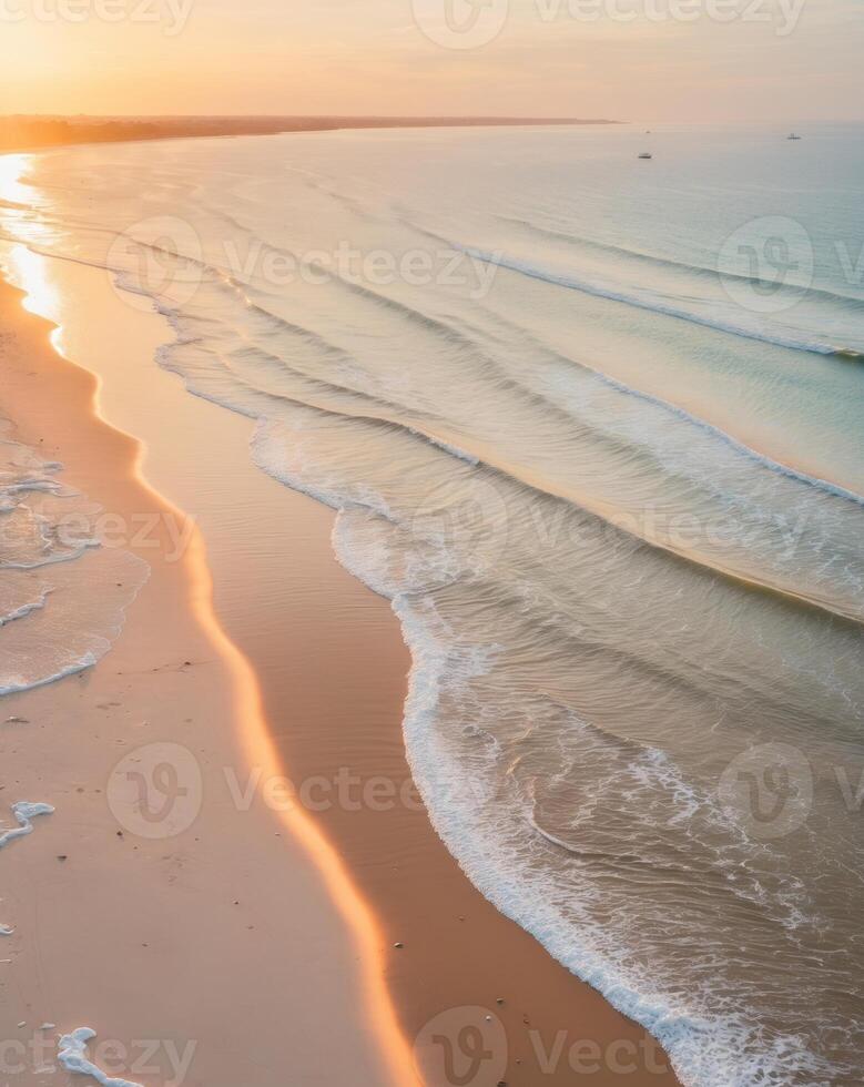 Breathtaking drone view of a golden sunrise over a serene beach and gentle waves photo