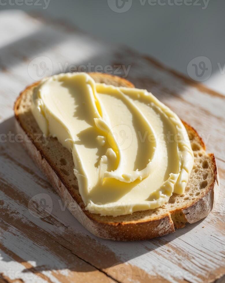 Creamy butter spread on rustic bread slice on wooden boardCreamy butter spread on rustic bread slice on wooden board. photo