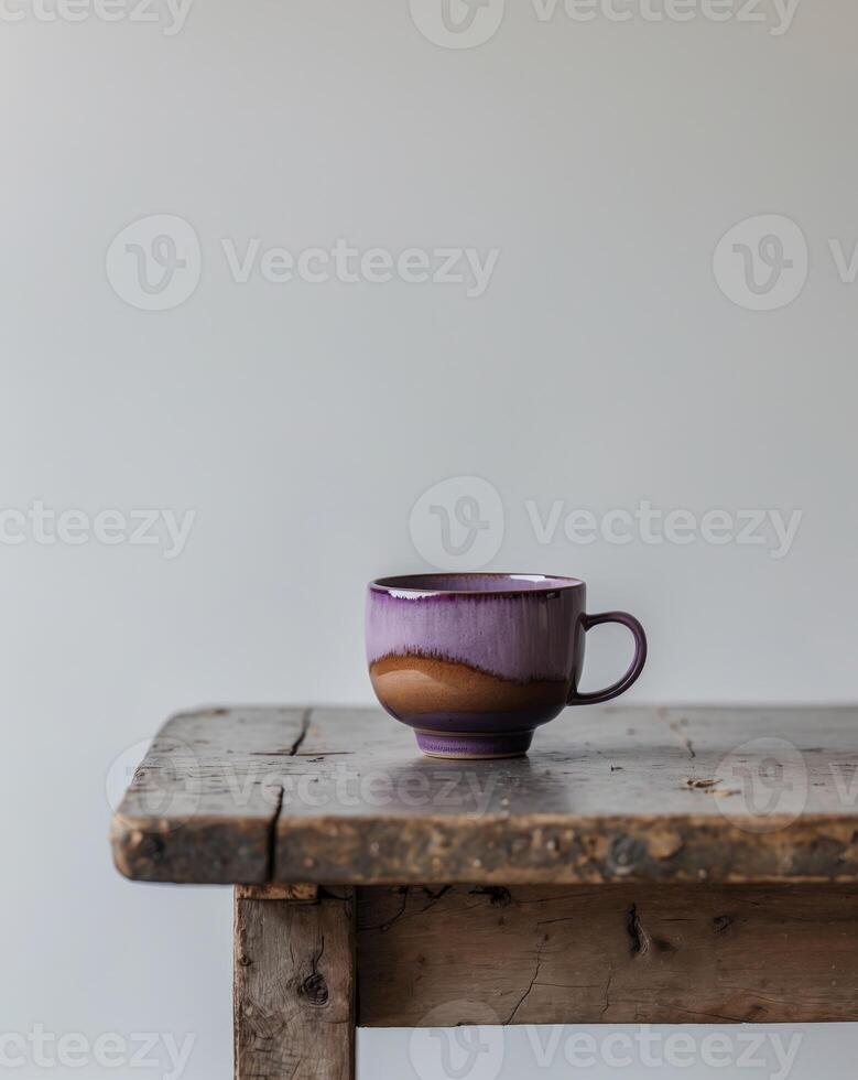 purple and brown cup sitting on a wooden table with a white wall in the backgroundpurple and brown cup sitting on a wooden table with a white wall in the background. photo