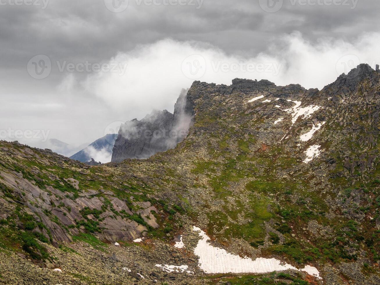 Dangerous gorge. Low clouds and beautiful rockies. photo