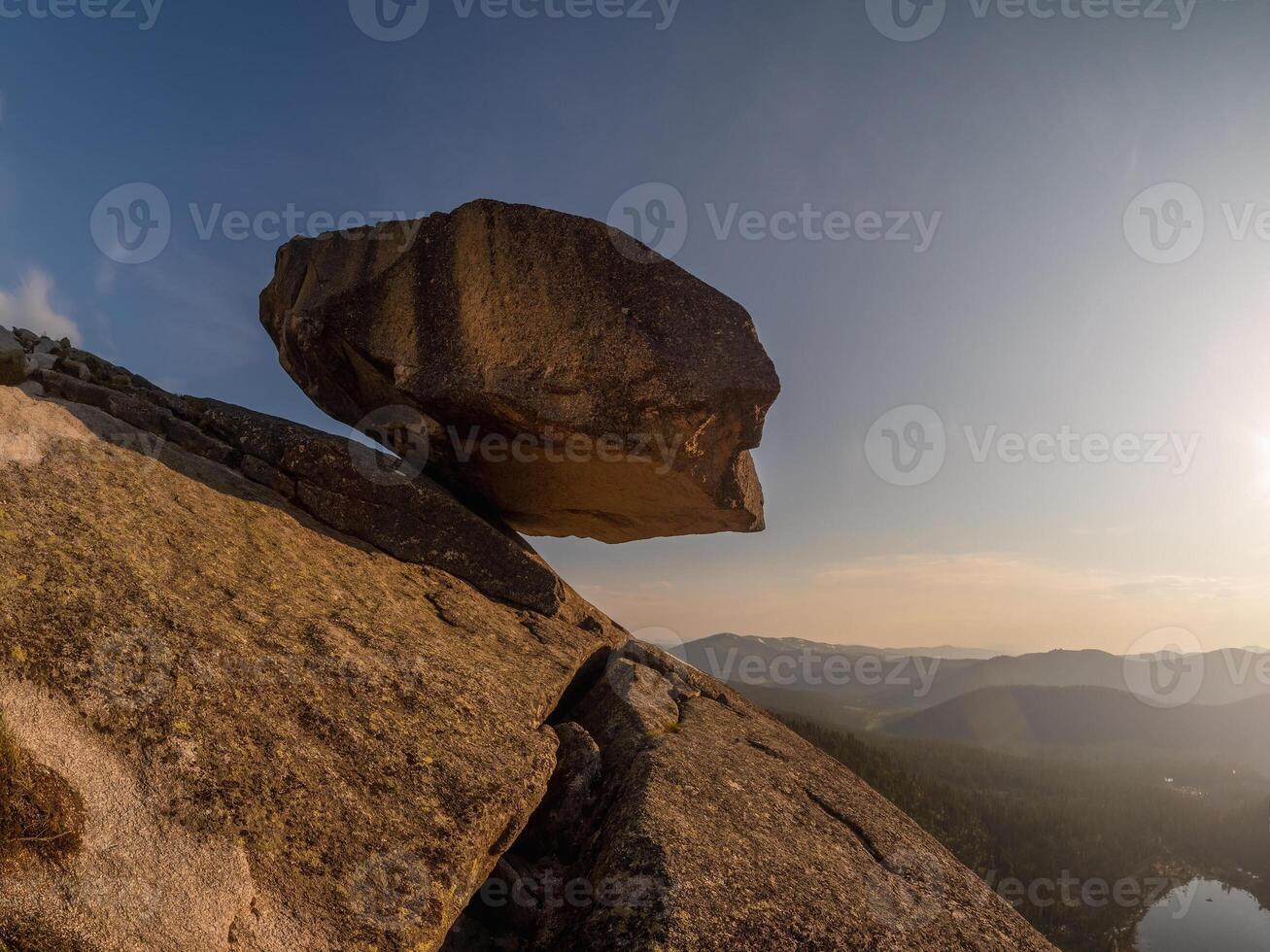 Large granite boulder hangs over the abyss. photo