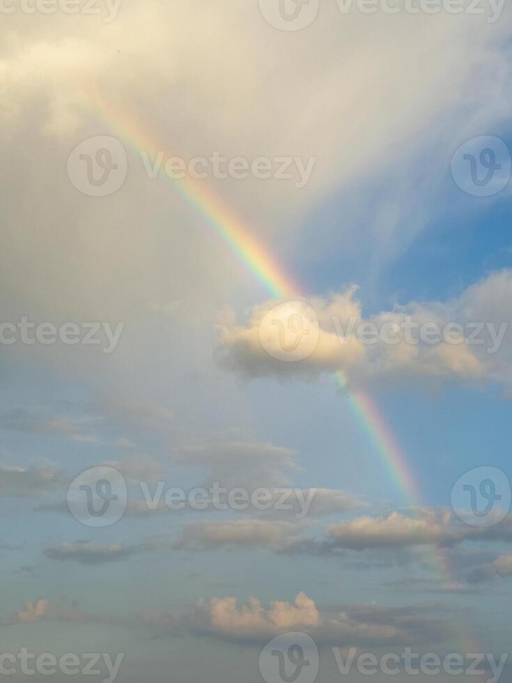 Beautiful rainbow in the sky over clouds. Vertical view. photo