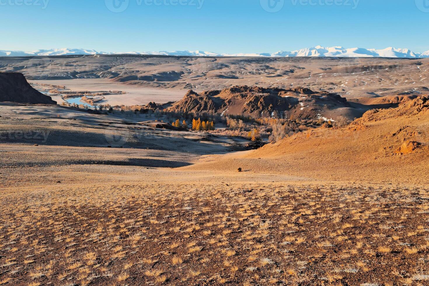 Bright autumn mountain steppe landscape. Awesome alpine view from pass to mountain valley in sunlight and great mountain silhouettes on horizon. Altai region. photo