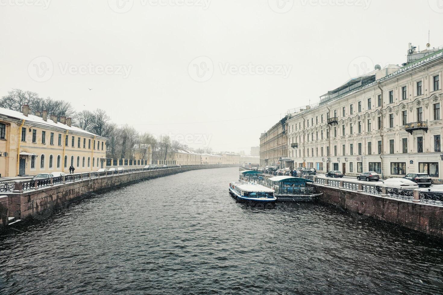 pleasure boat is moored on the river in a spring snowstorm photo