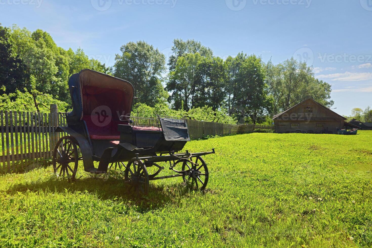 An ancient phaeton carriage on a green rural lawn photo