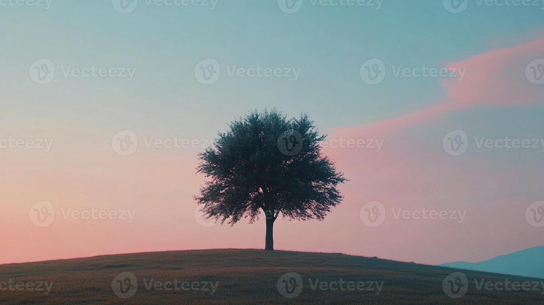 Serene lone tree on a grassy hill at sunrise showcasing pink pastel sky gradients and tranquil nature photo