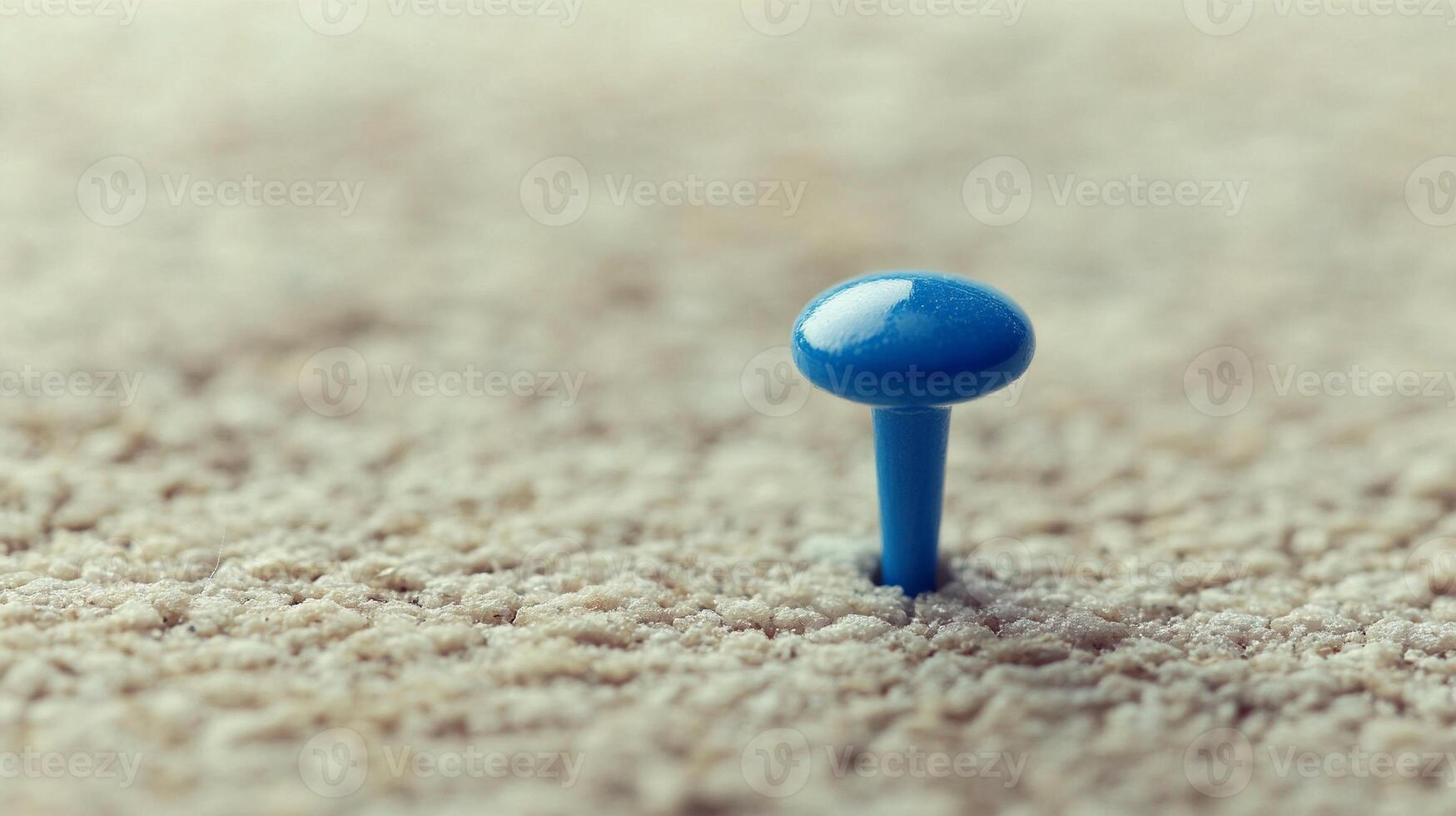 Single blue pushpin inserted into textured corkboard in warm natural lighting photo