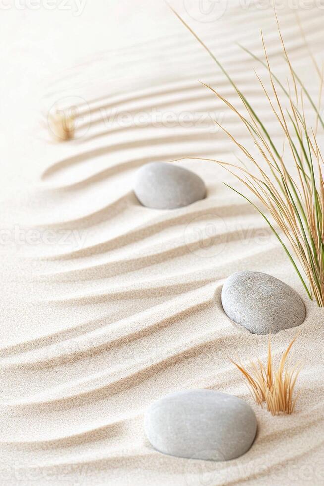 Windblown sand creates gentle, flowing patterns in beige tones, accented by smooth stones and delicate grasses, evoking a calming and peaceful atmosphere photo