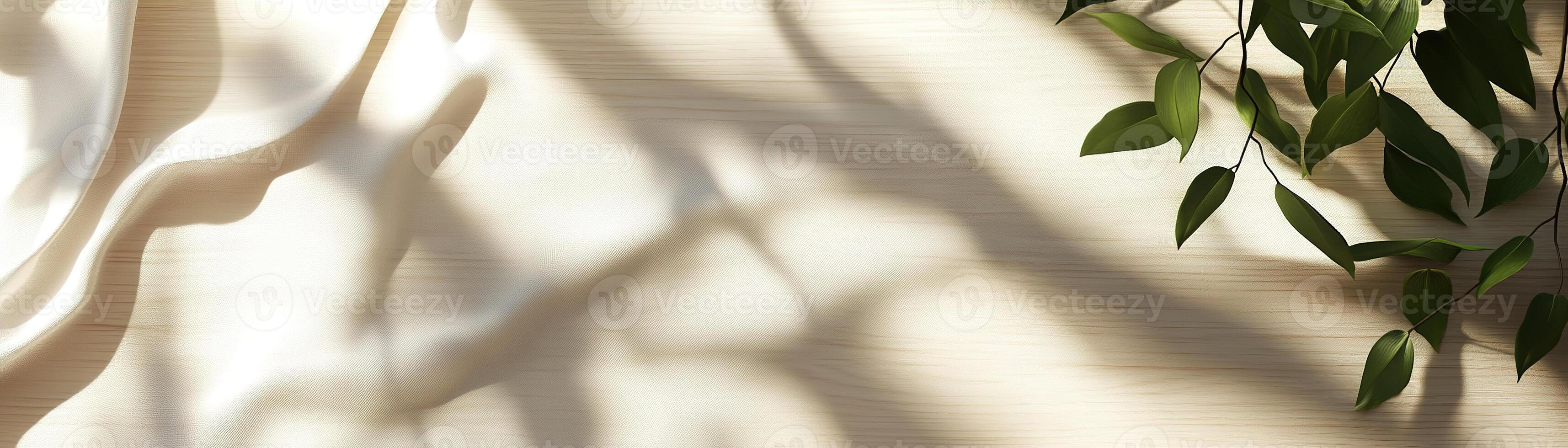 Light wooden surface showcases calming natural shadows from greenery and fabric folds, offering a serene and versatile backdrop ideal for fashion and lifestyle presentations photo