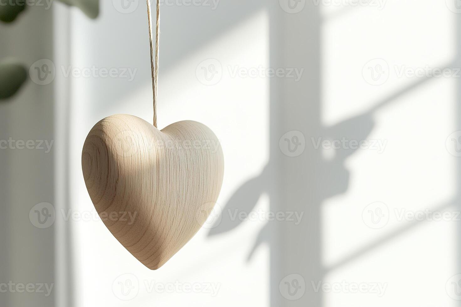 A simple wooden heart ornament hangs against a neutral light background, showcasing a modern Nordic aesthetic. The stylish design creates a peaceful atmosphere, perfect for text placement photo