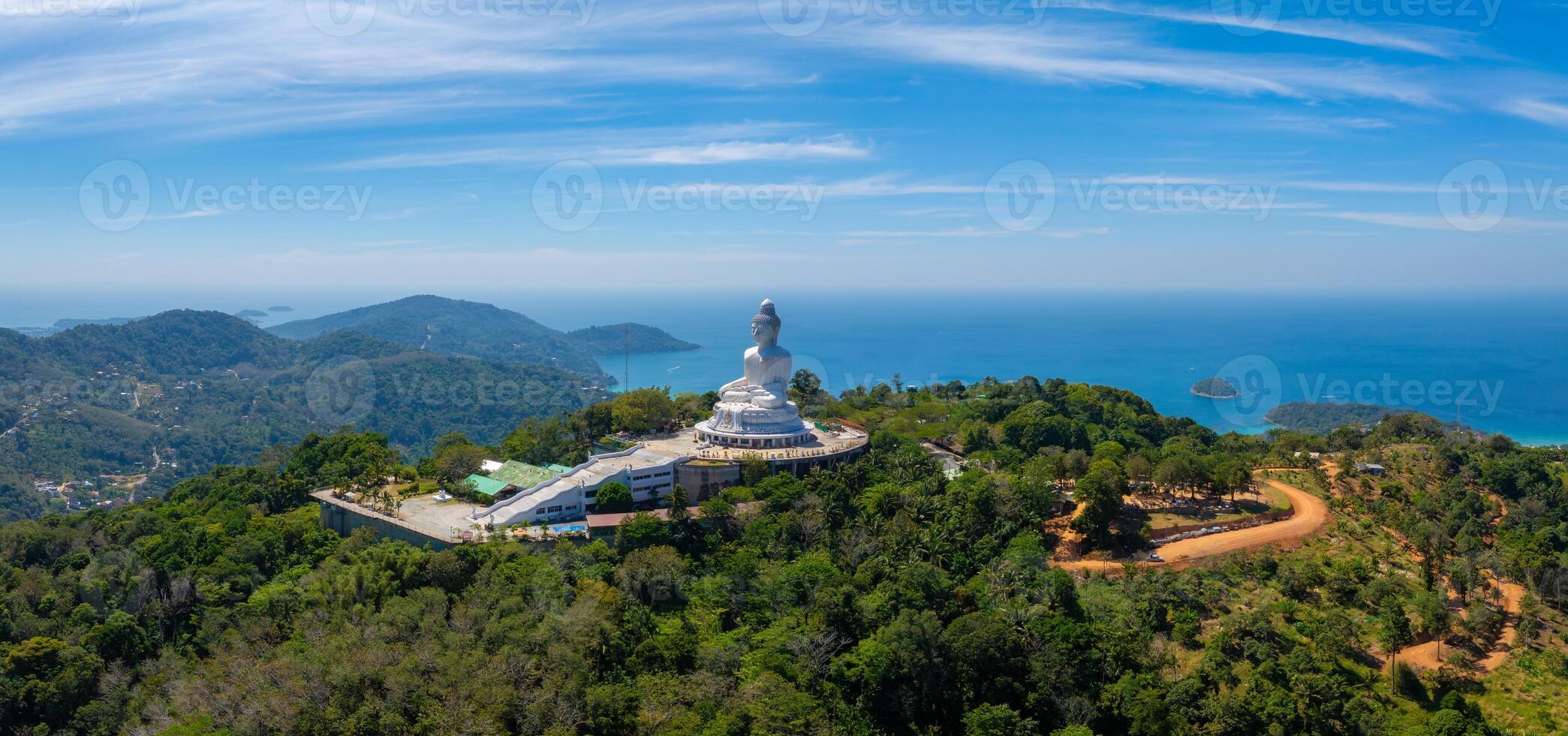 Aerial view of the white marble Big Buddha statue on a green hill in Phuket, Thailand, with the Andaman Sea and islands visible in the background. photo