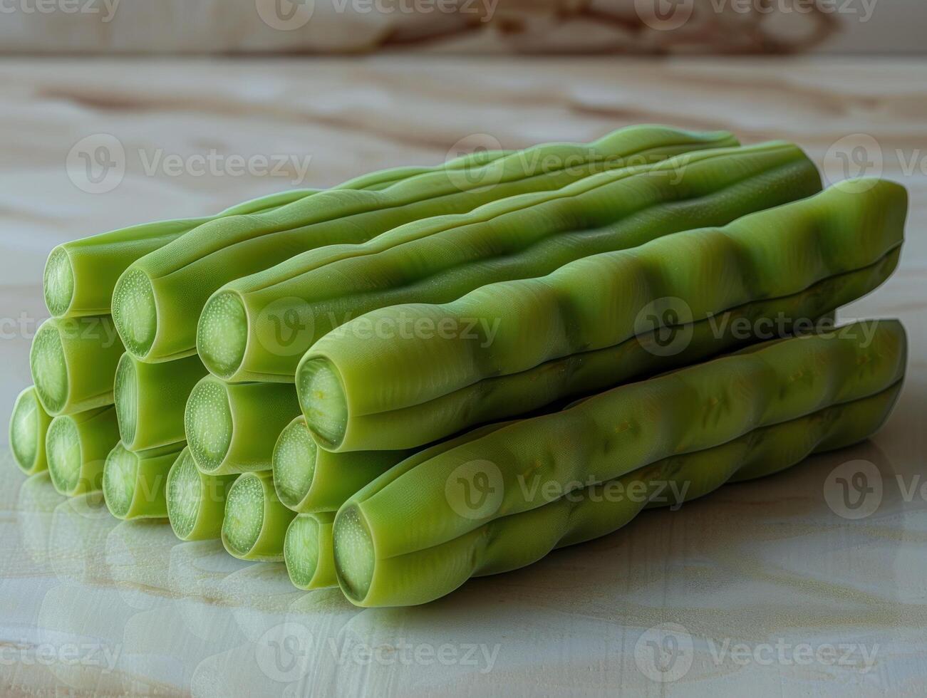A close-up view of green beans stacked on a white marble surface photo