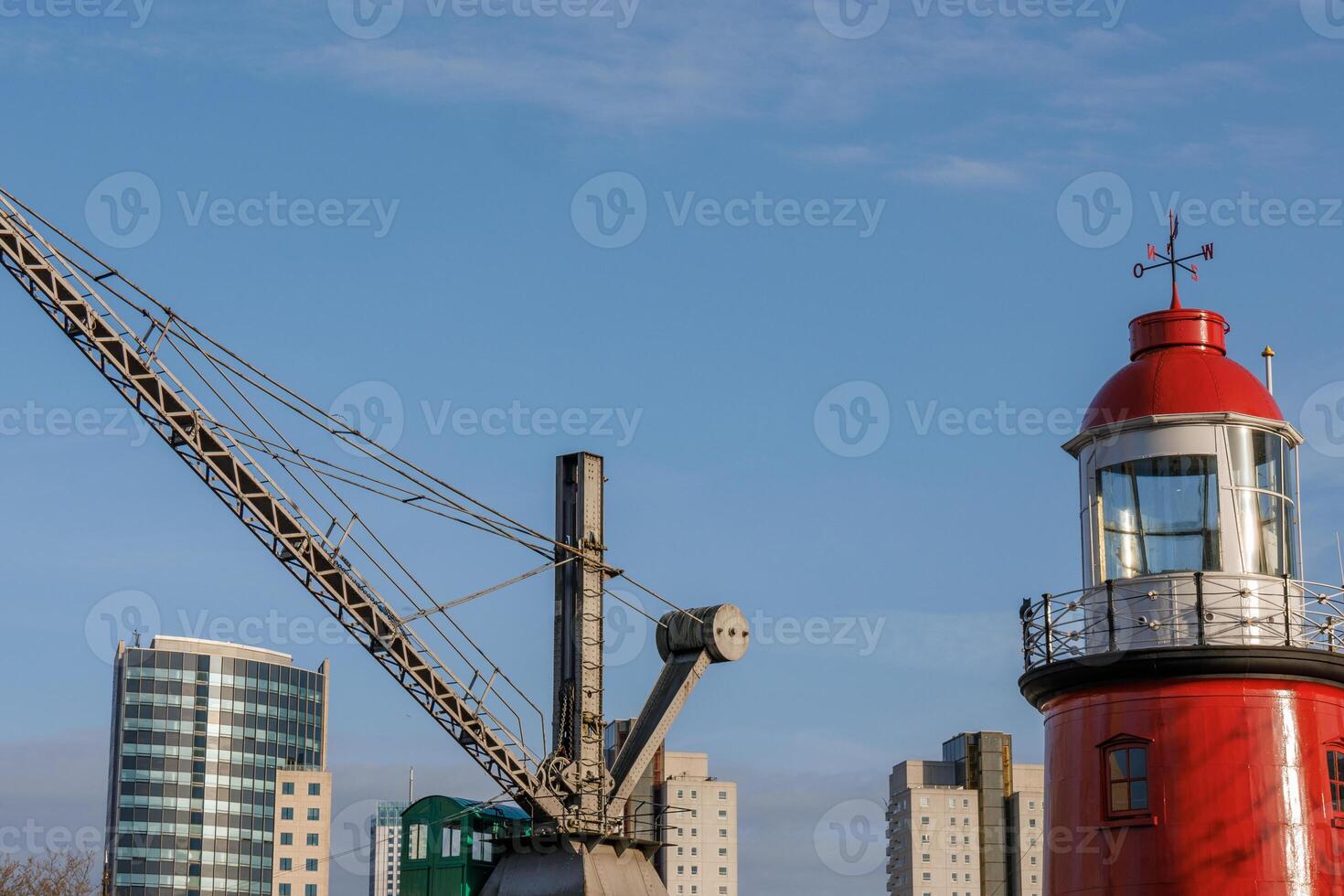 A large crane iand a lighthouse in rotterdam photo