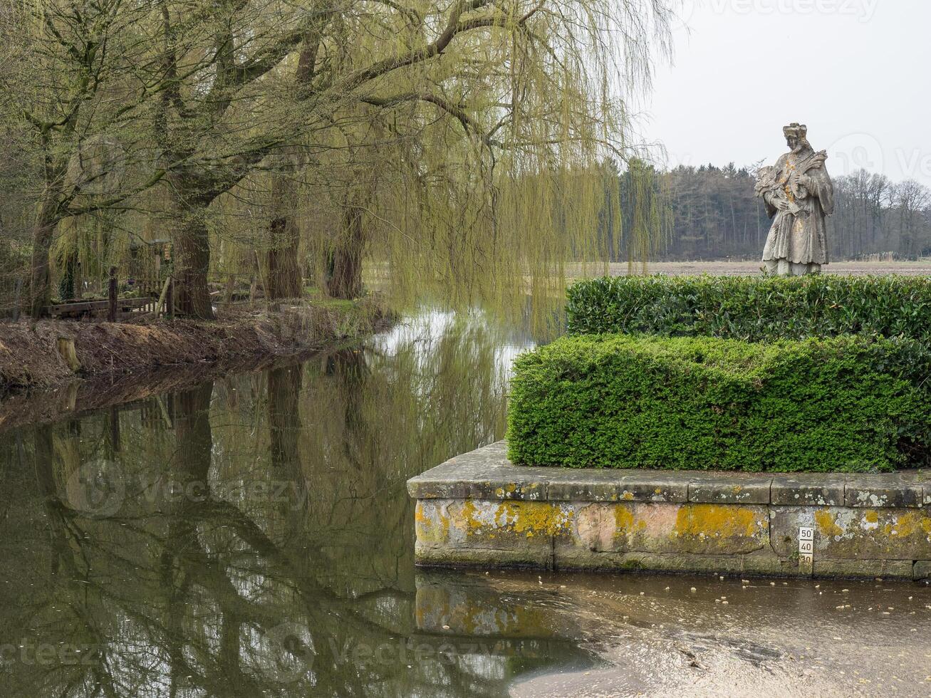 A statue of a man standing on a stone wall photo