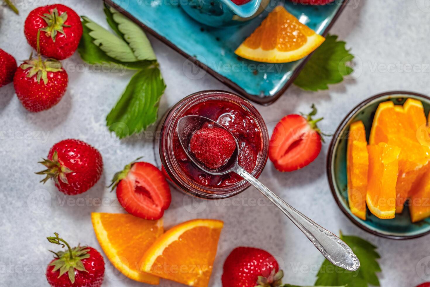 Delicious homemade strawberry jam with fresh strawberries and orange slices photo