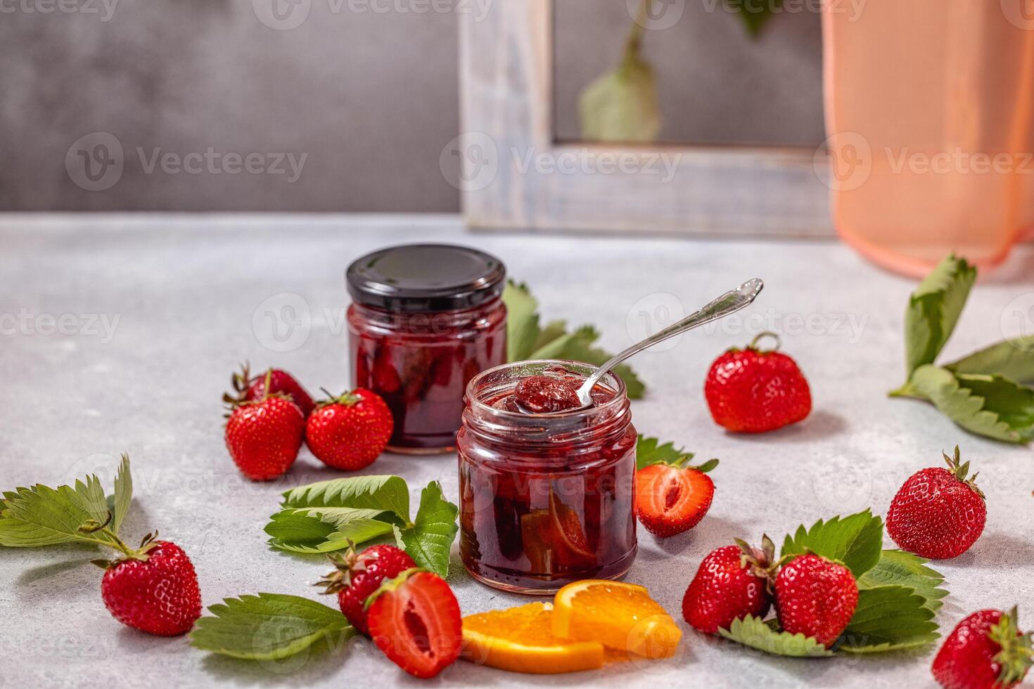 Homemade strawberry jam with fresh strawberries and orange slices photo