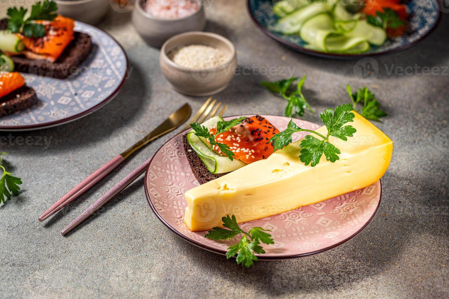 Gourmet cheese wedge with smoked salmon and cucumber canapes on rye bread photo