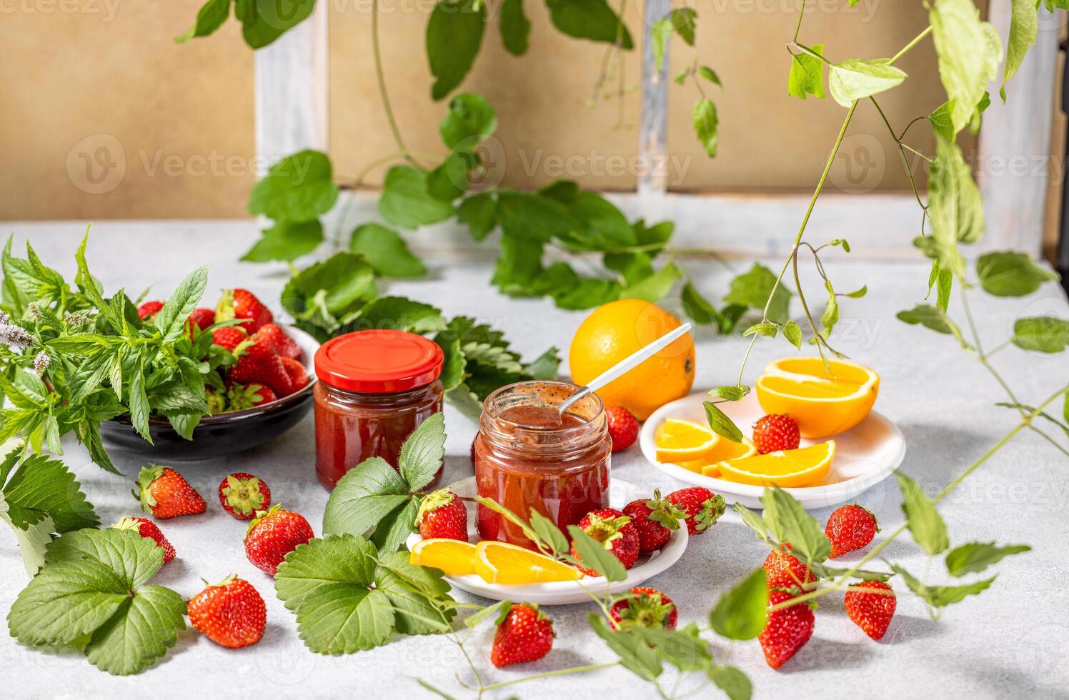 Homemade strawberry jam with fresh strawberries, orange slices and mint leaves photo