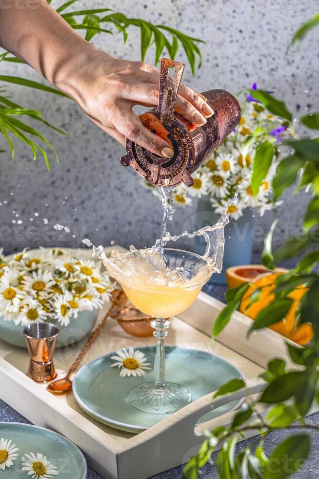 Bartender pouring cocktail into elegant glass, creating splash with jigger photo