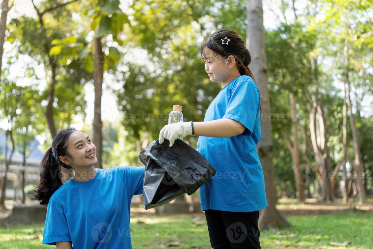Family members working together to collect garbage during a community volunteer day in the park photo