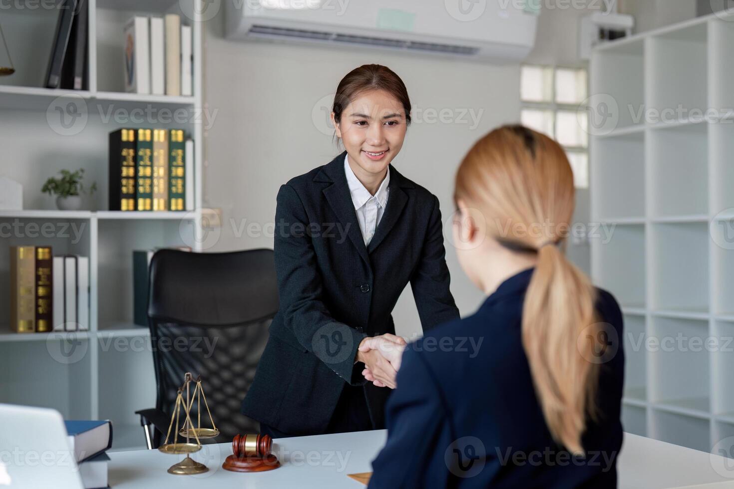 Lawyer shaking hands with a client after a successful contract discussion in a professional office photo
