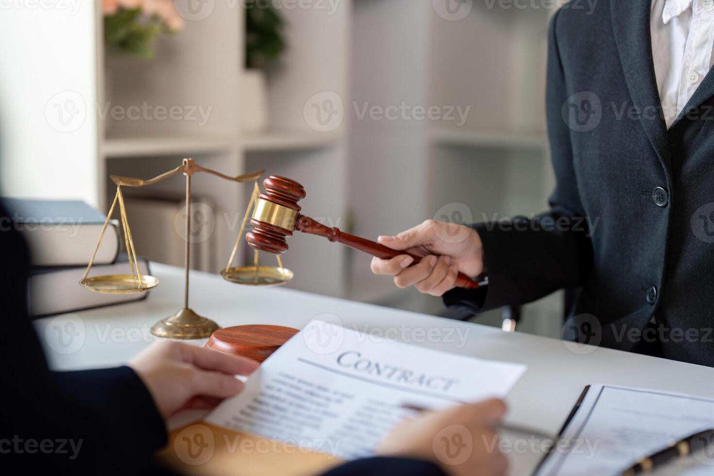 Lawyer discussing a contract with a client while demonstrating authority with a gavel in a professional setting photo