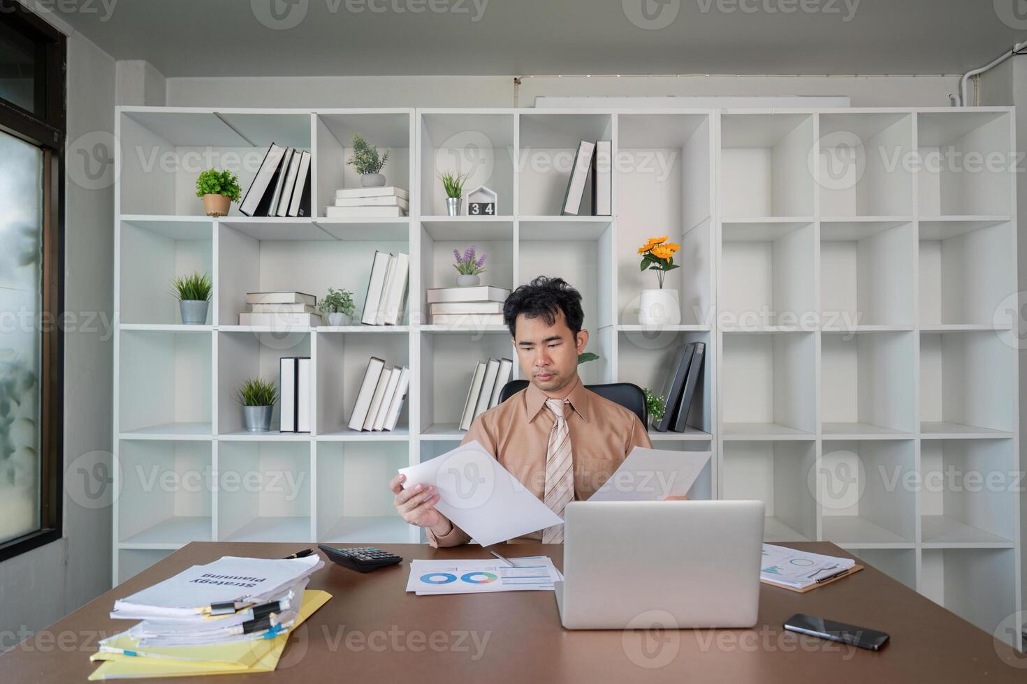 Businessman analyzing financial reports in a modern workspace, maximizing productivity with organized documentation photo