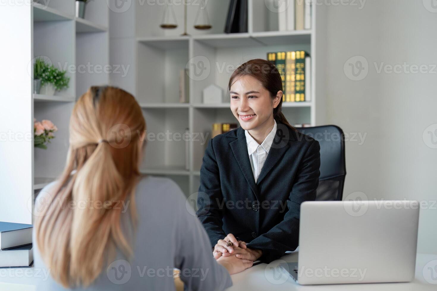 Smiling lawyer consulting with a client about contract options in a contemporary office environment photo