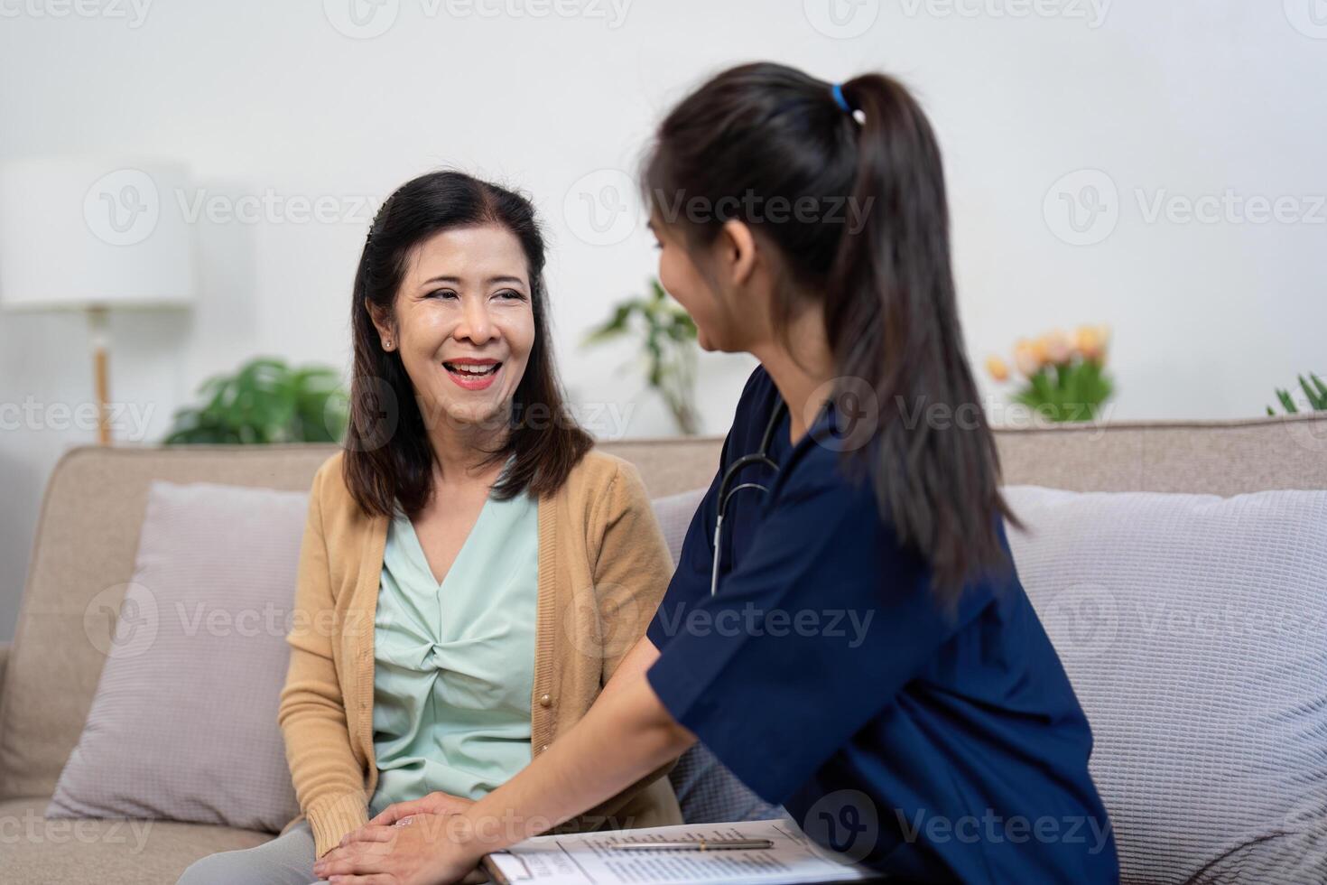 Warm-hearted caregiver sharing a joyful moment with elderly patient in a nurturing environment photo