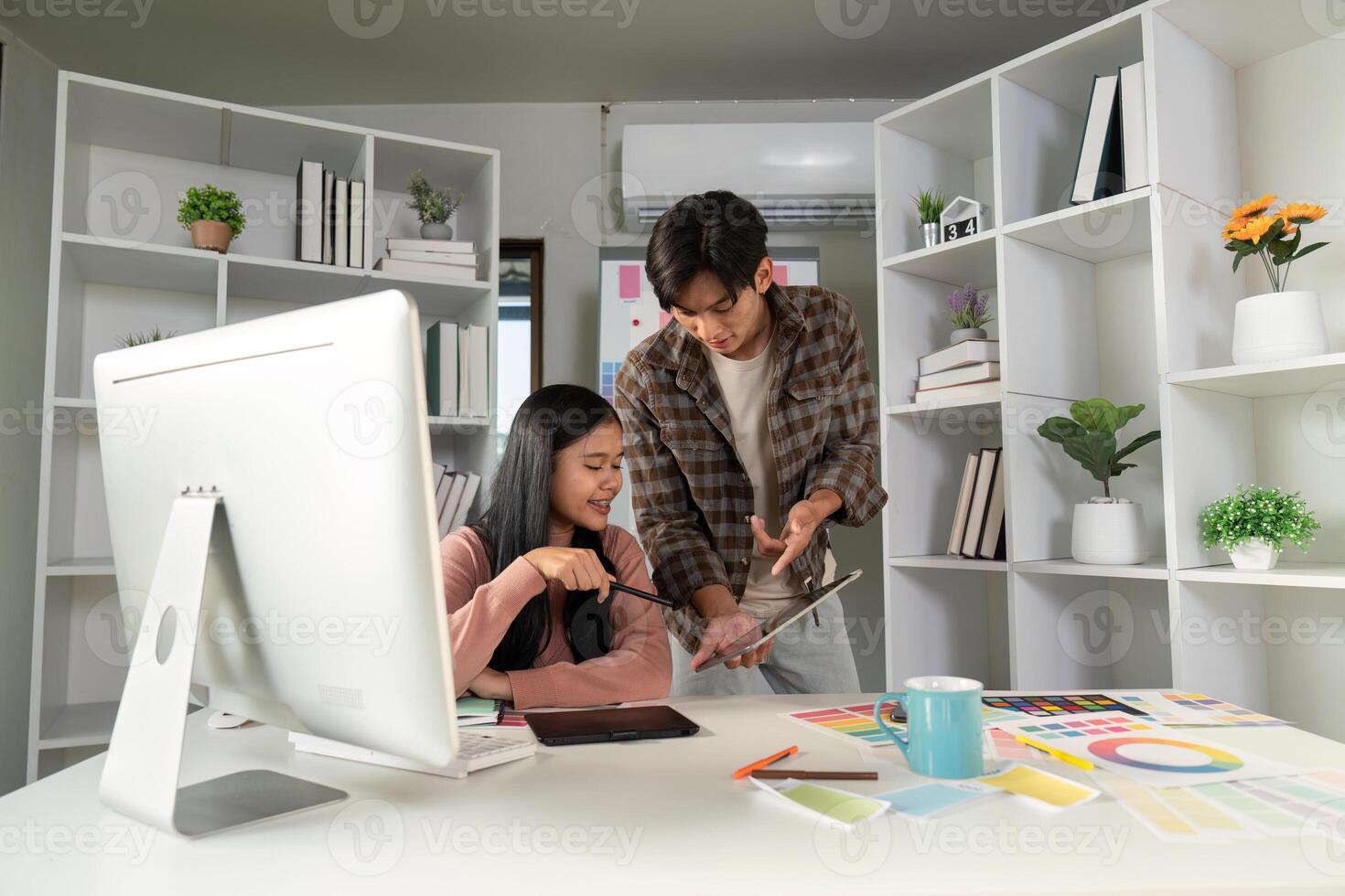 Creative design team collaborating at a modern workspace, discussing project ideas on a tablet photo
