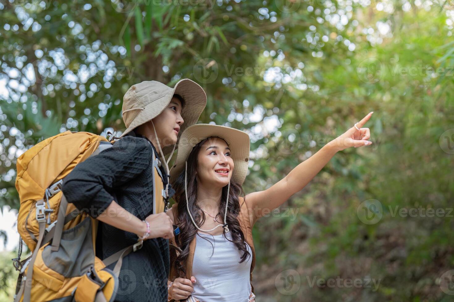 LGBT couple exploring nature, pointing out sights during their hiking adventure photo