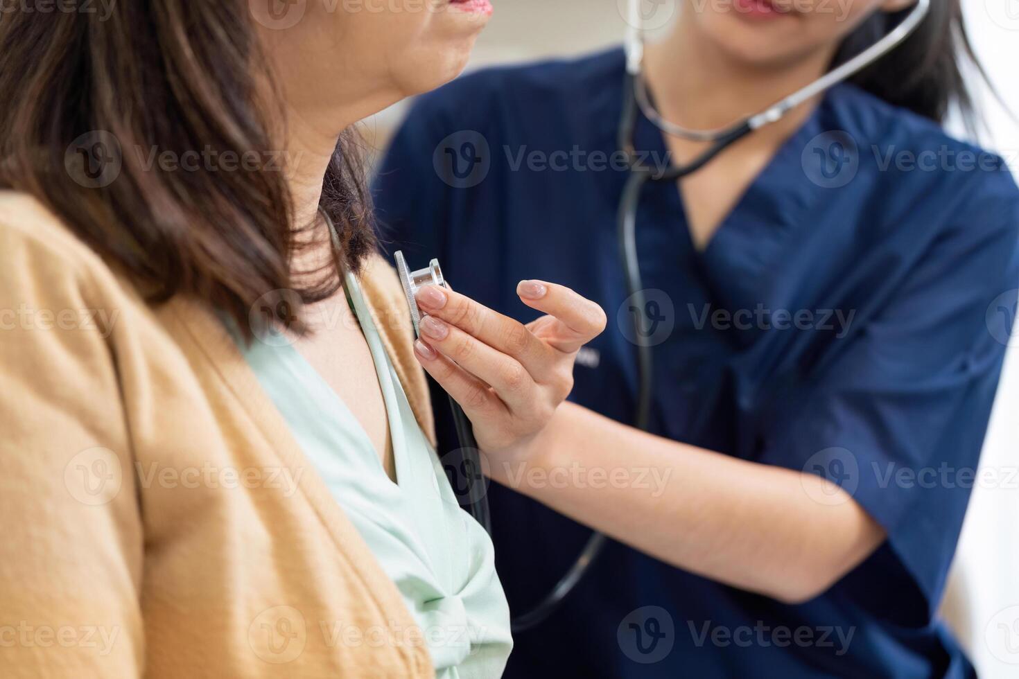 Caregiver using stethoscope on elderly patient during a health checkup photo