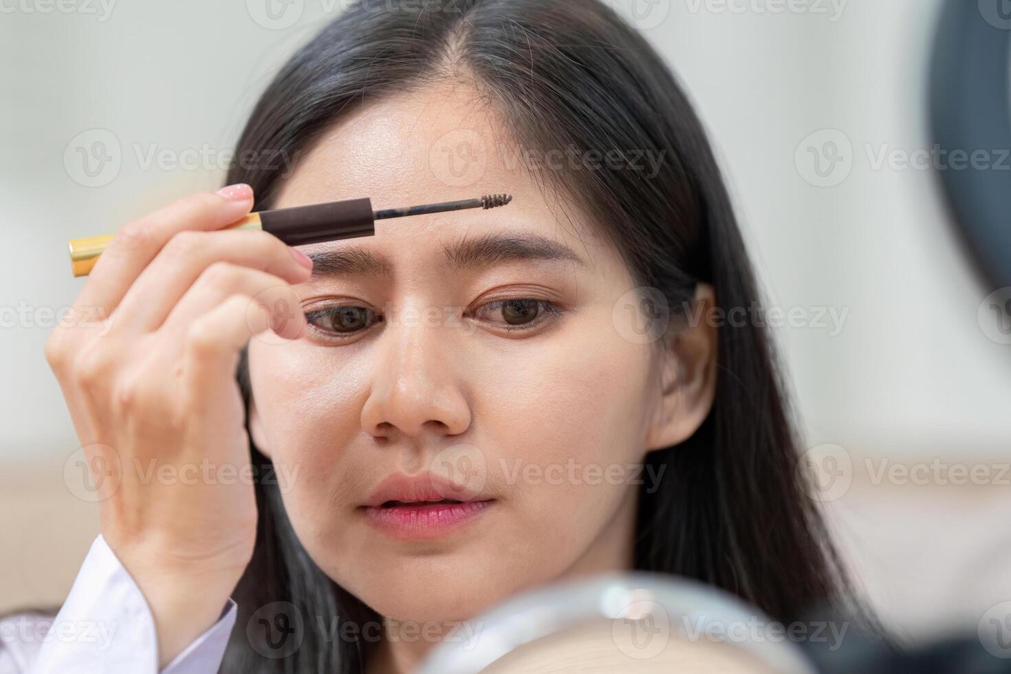 Beauty broker using eyebrow gel during a live broadcast makeup session photo
