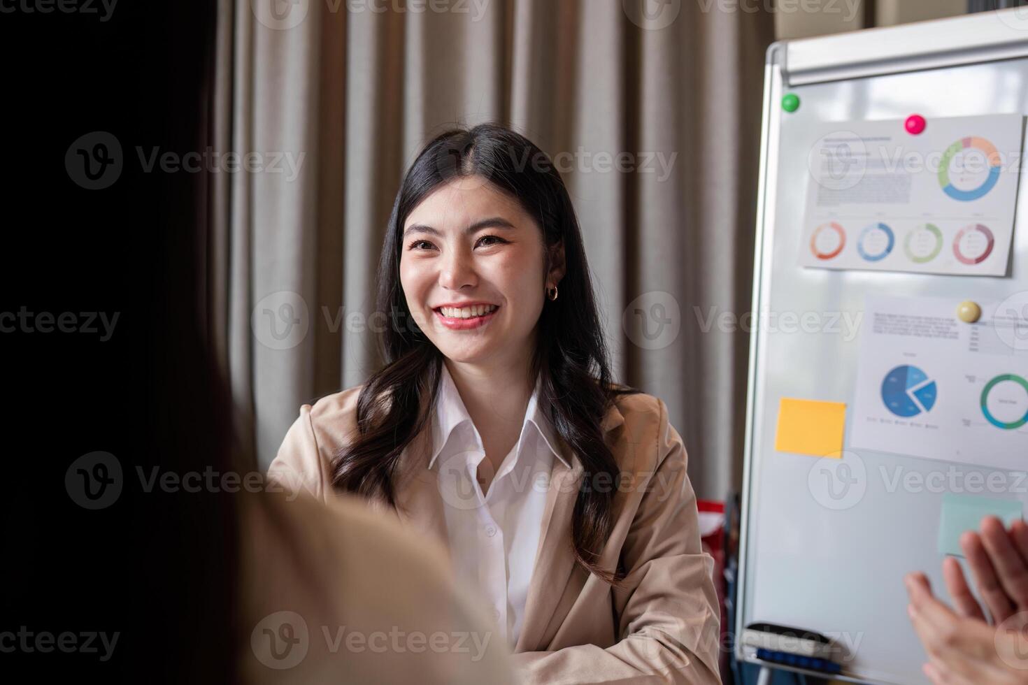 Cheerful female professional engaging in collaborative discussions with team in modern office setting photo