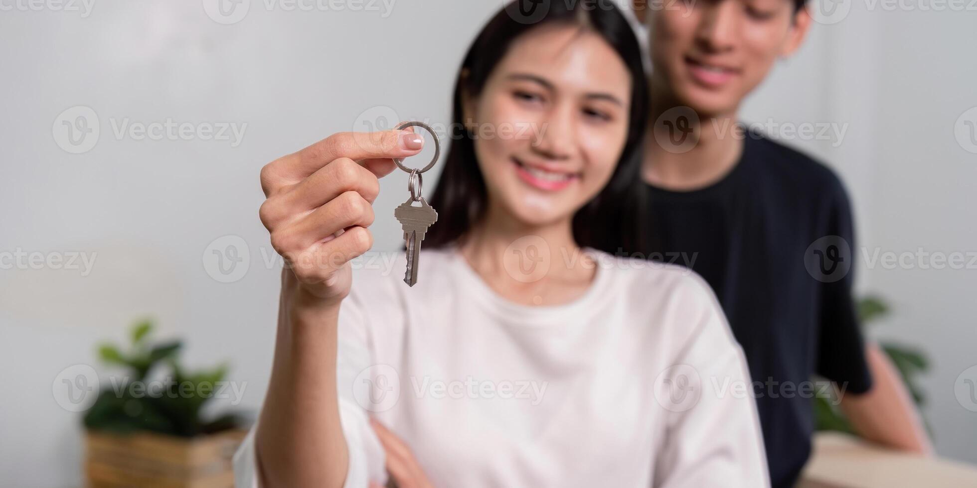 Happy couple celebrating their new home with keys, symbolizing a fresh start and new beginnings photo